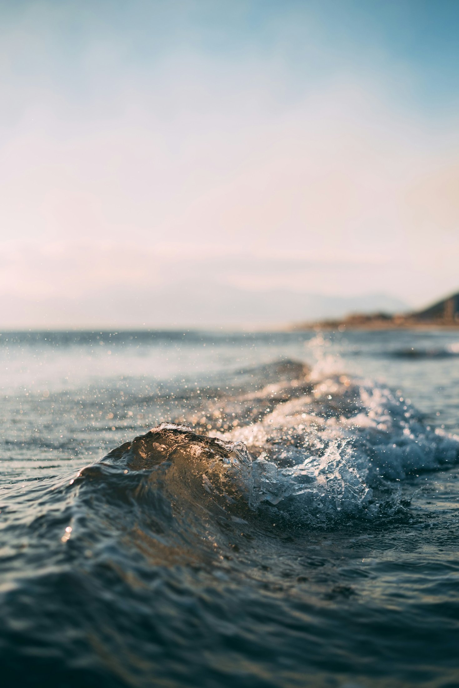 A calm open ocean beneath a long flat horizon at dusk